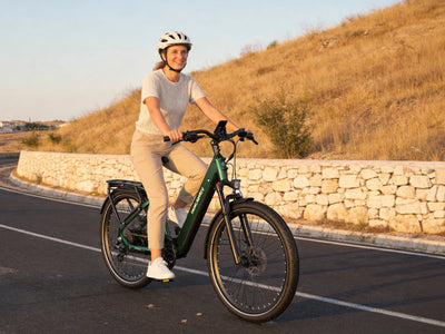 Woman riding a green Dukawey FUGL Pro beside a stone wall